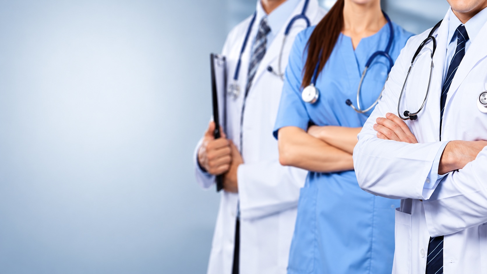 Doctors and a nurse standing together with arms folded