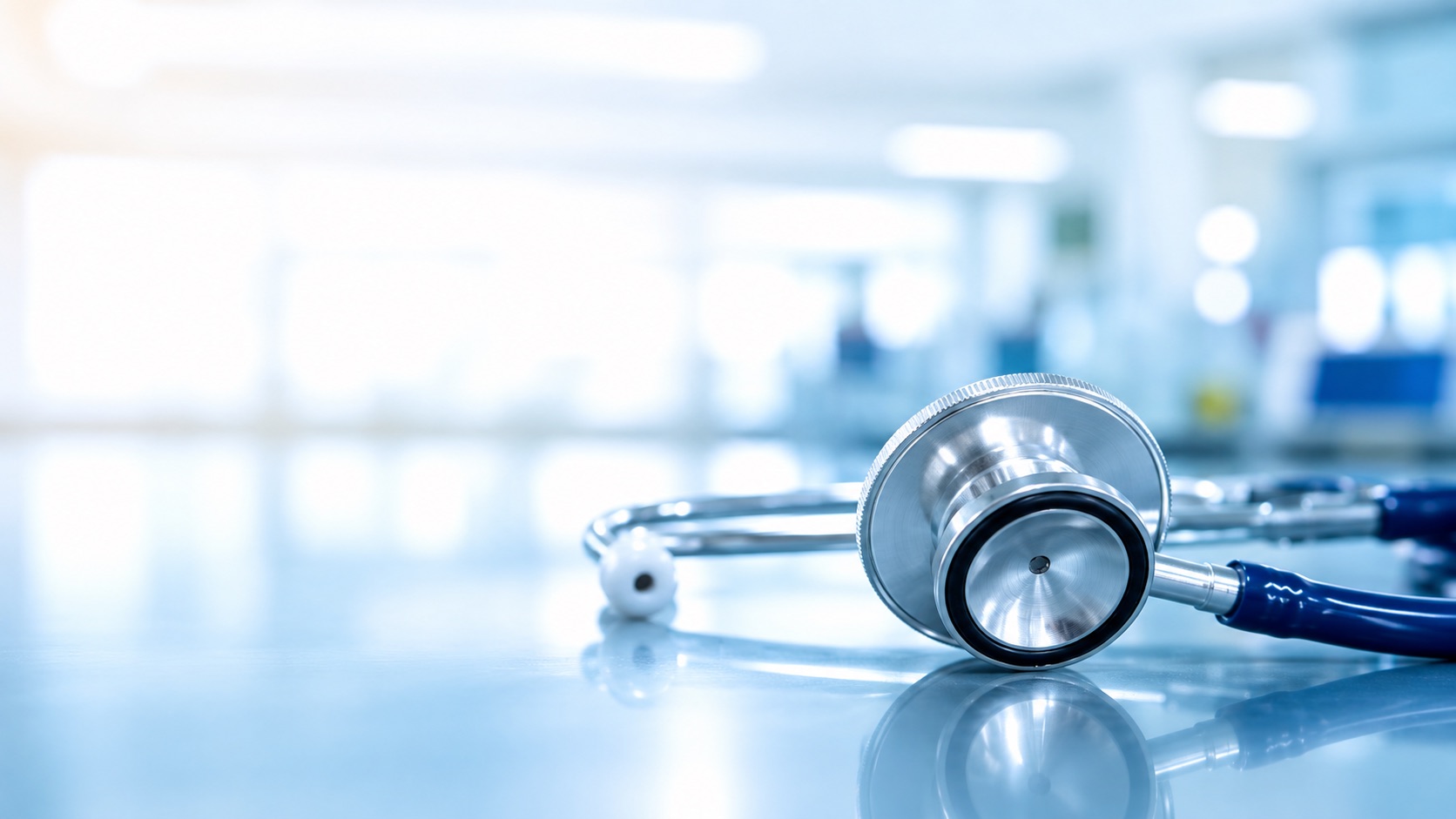 A stethoscope resting on a reflective surface in a bright clinic